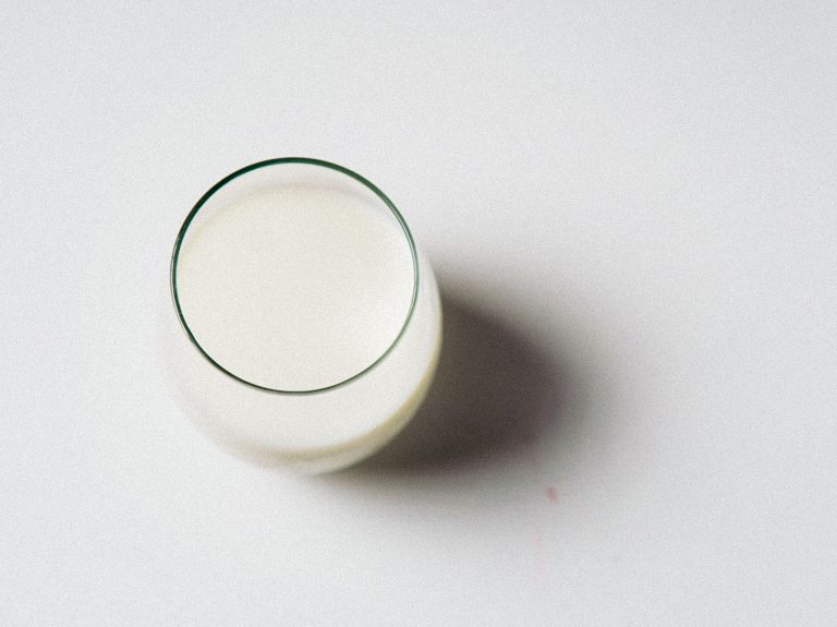 Verre de lait minimaliste sur fond blanc