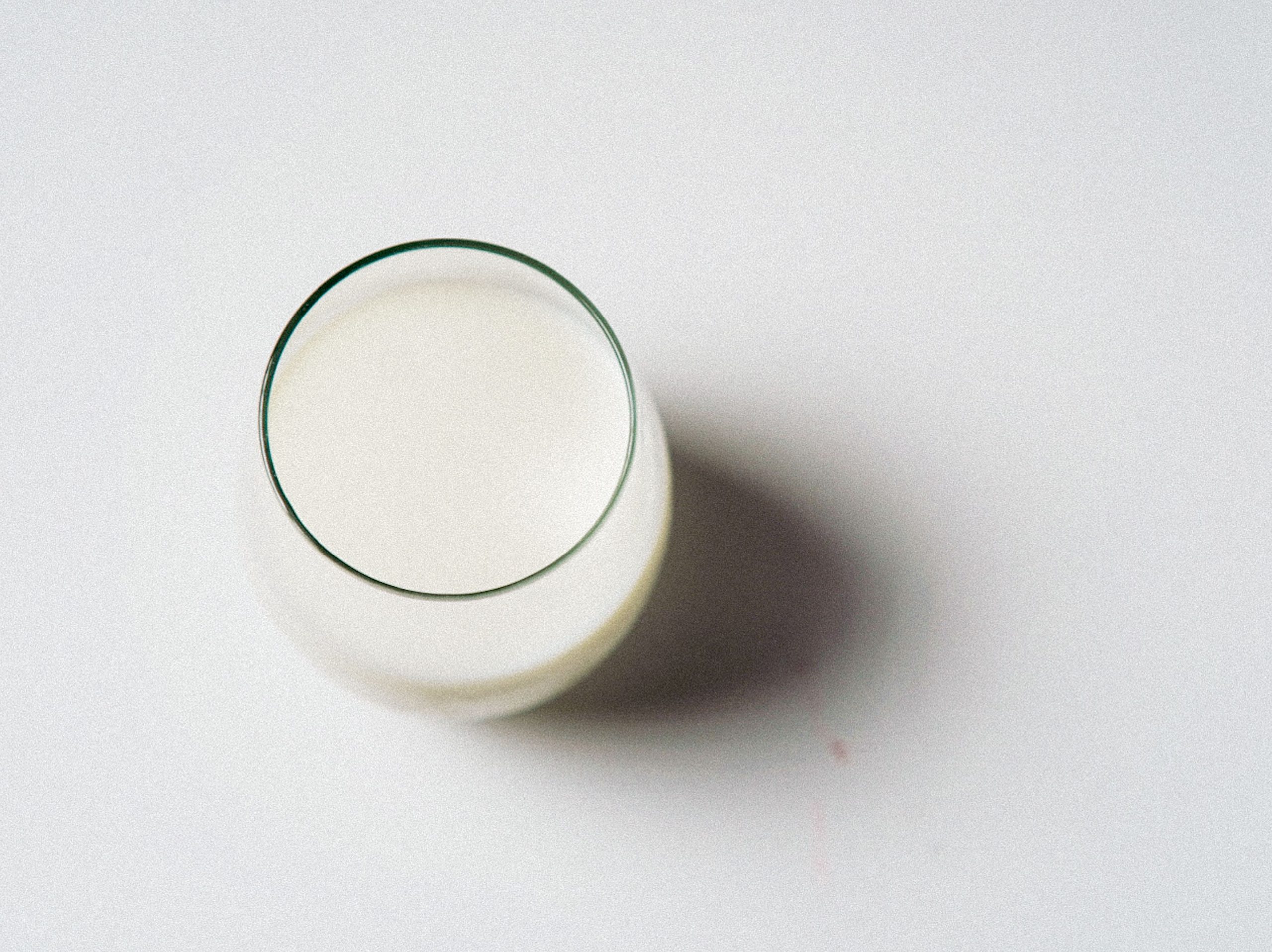 Verre de lait minimaliste sur fond blanc