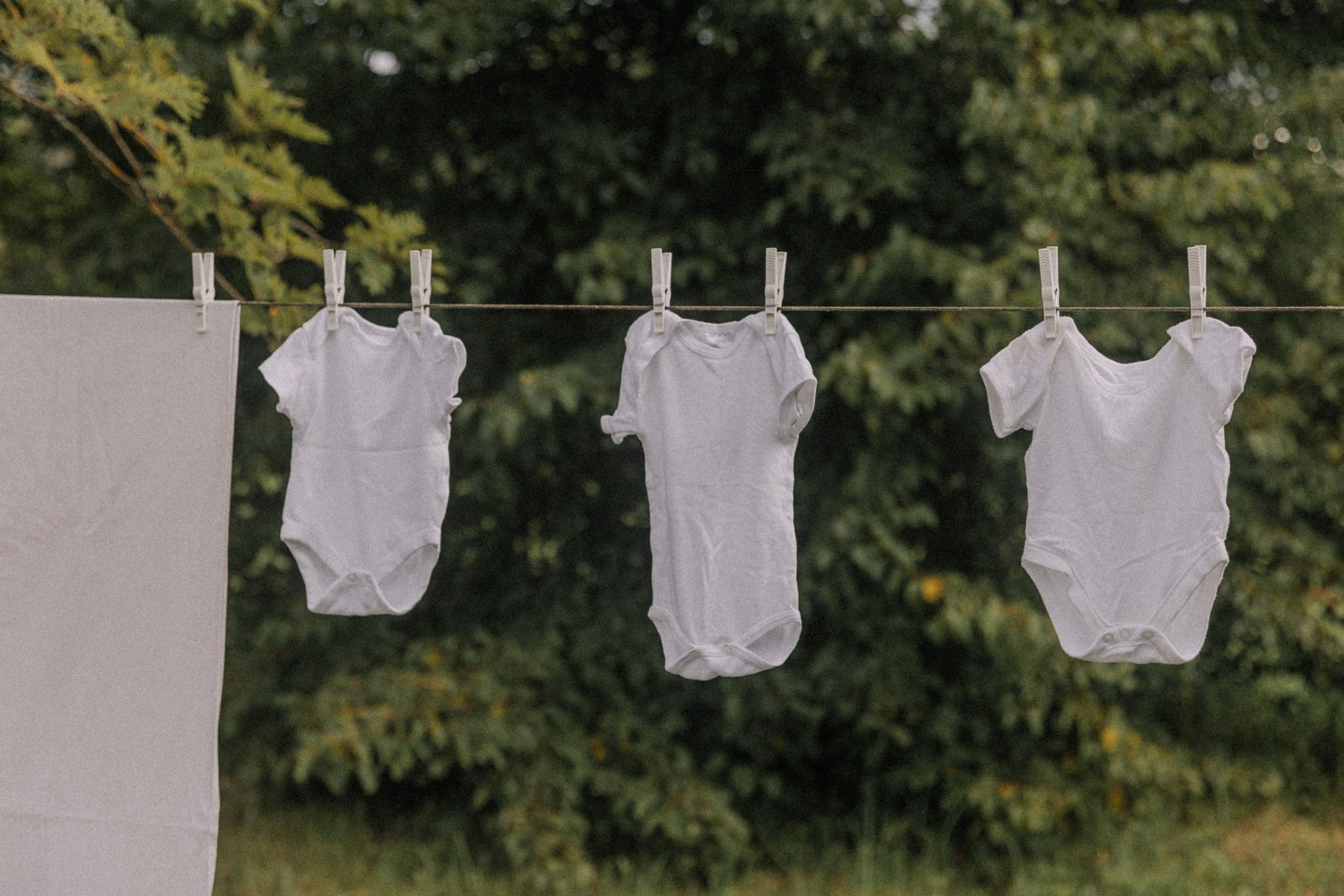 Bodys bébé blancs sèchent sur corde