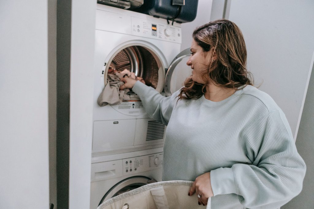 Femme chargeant linge dans machine moderne