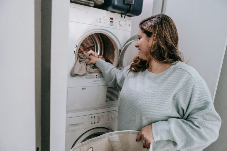 Femme chargeant linge dans machine moderne