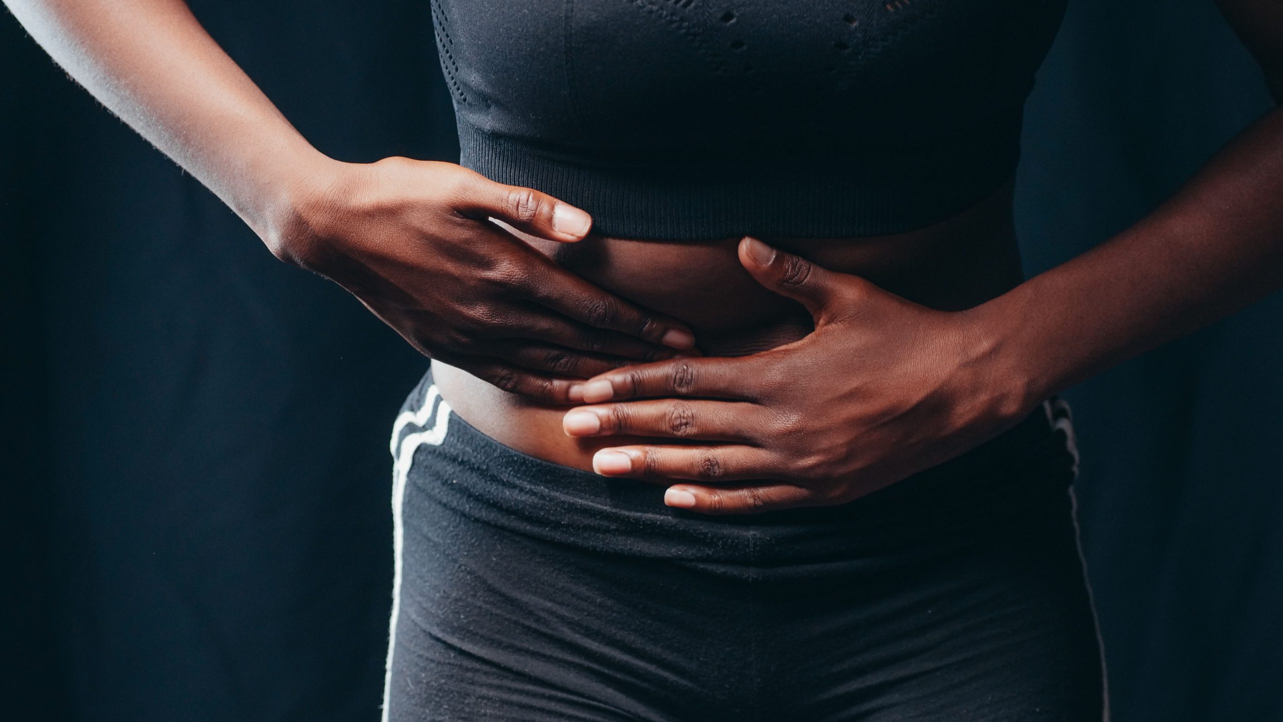 Personne se tenant l'abdomen en signe de douleur
