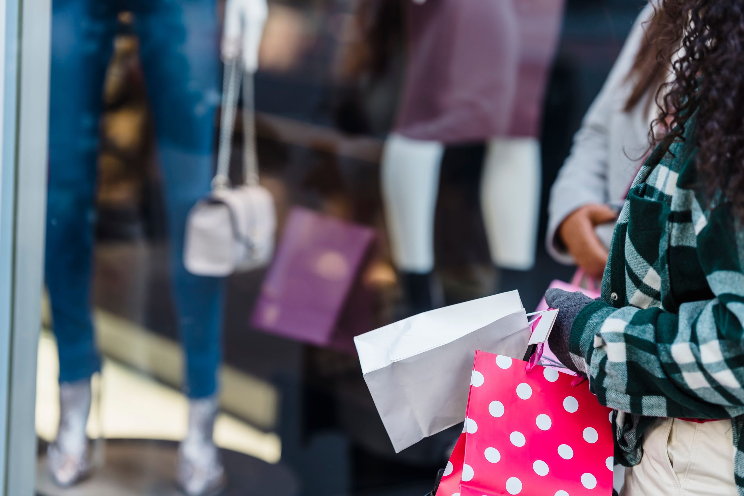 Femmes amies avec sacs shopping près comptoir boutique