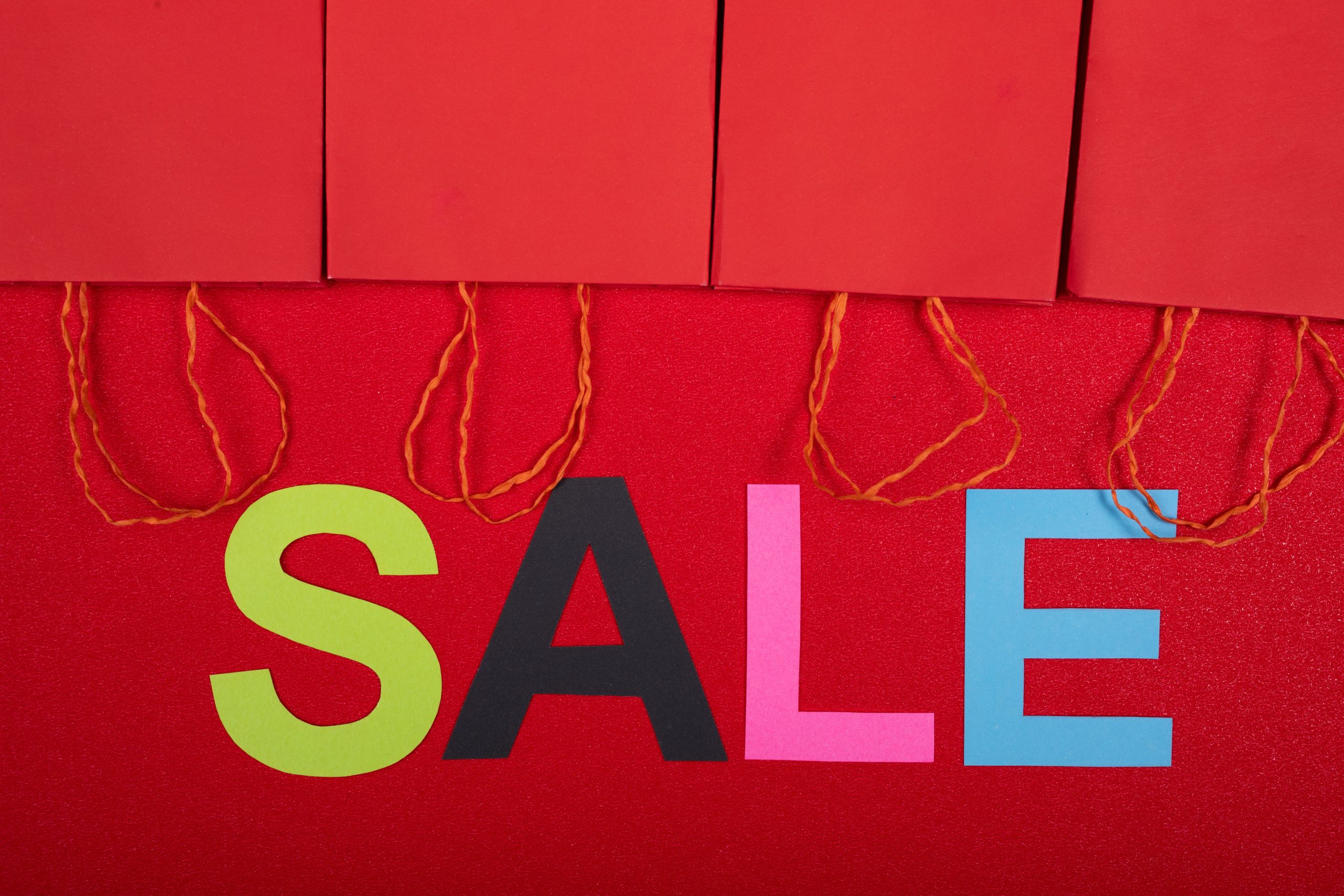 Panneau soldes coloré avec sacs shopping rouges