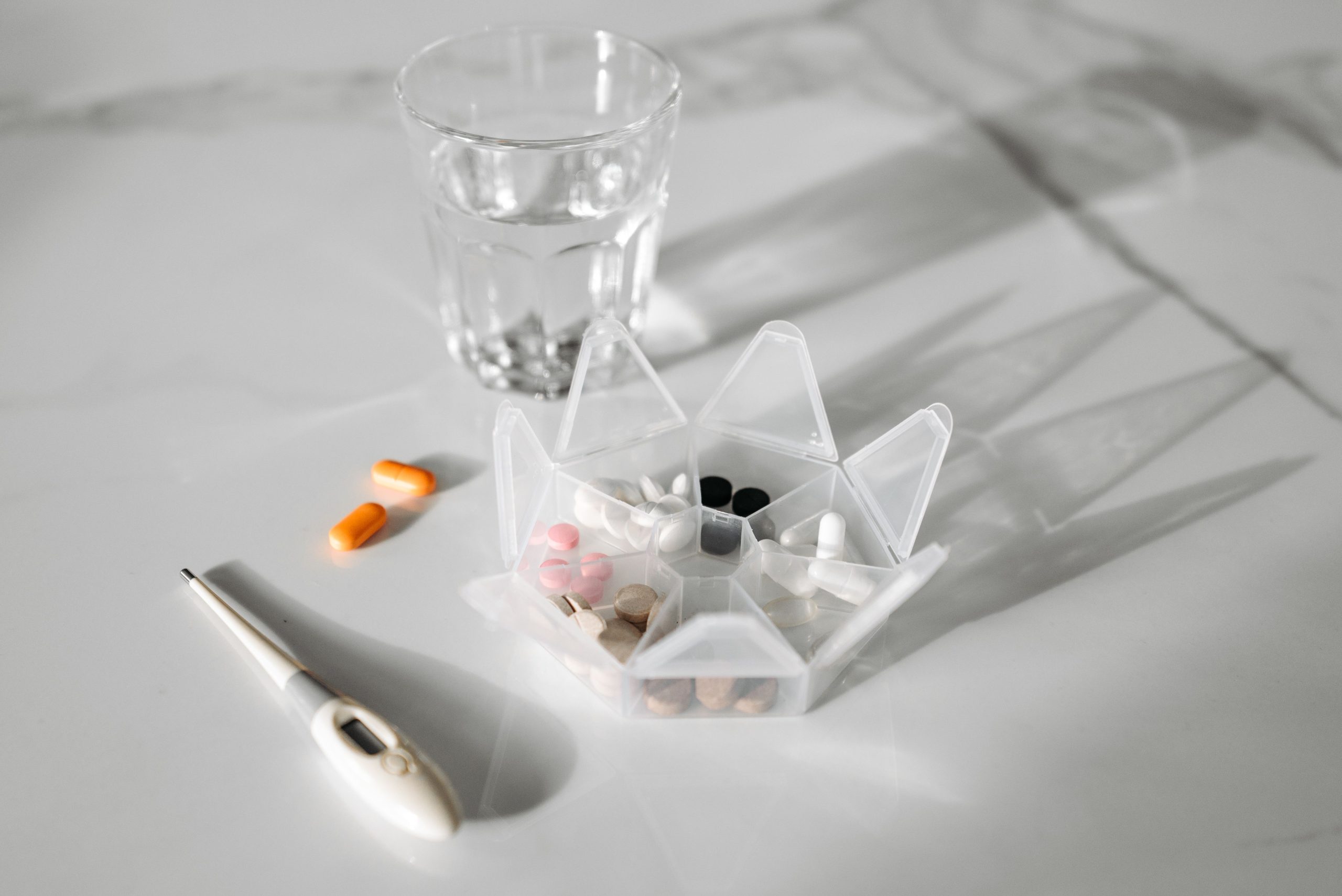 Pilulier avec médicaments et verre d'eau