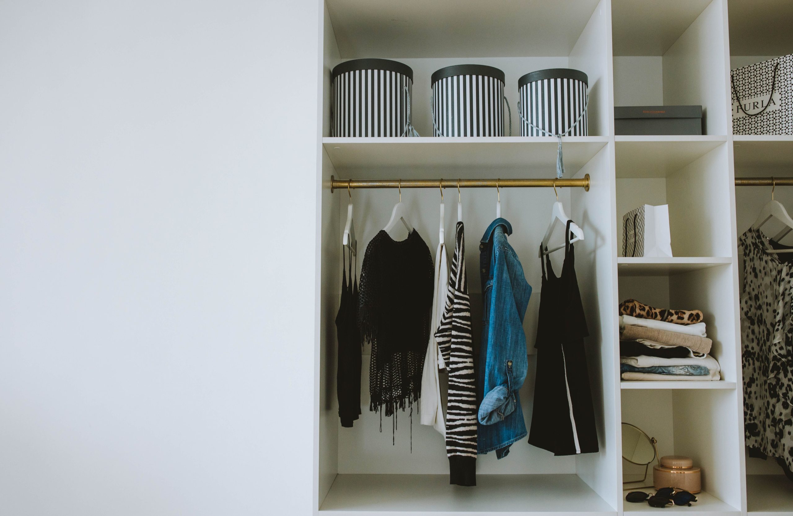 Garde-robe organisée avec vêtements, cintres et boîtes de rangement