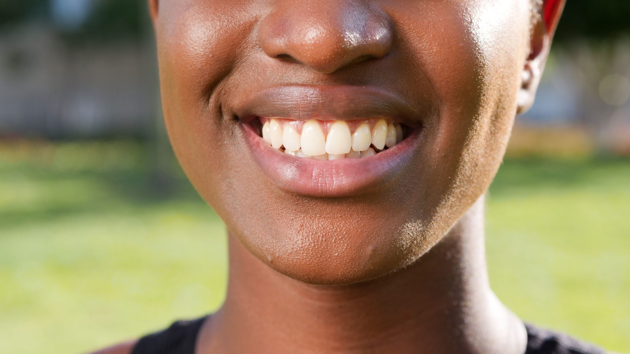 Personne souriante montrant dents et lèvres en extérieur